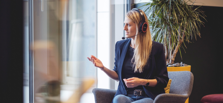 Woman looking at the window and speaking English fluently with the Pronounce headset